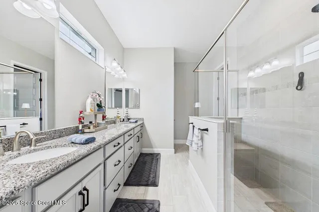 a spacious bathroom with a granite countertop sink mirror and a shower