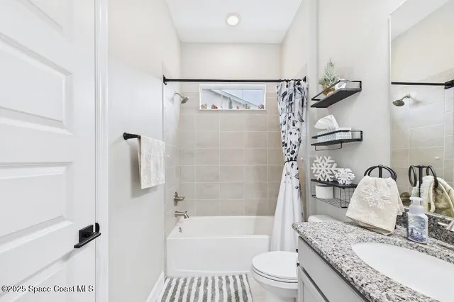 a bathroom with a granite countertop sink toilet mirror and shower