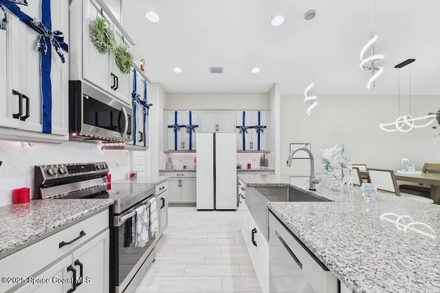 a kitchen with stainless steel appliances granite countertop a sink stove and refrigerator