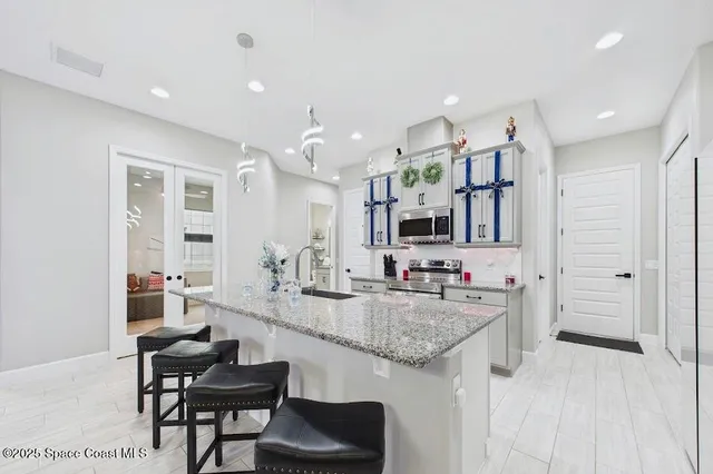a large kitchen with kitchen island a sink and a refrigerator