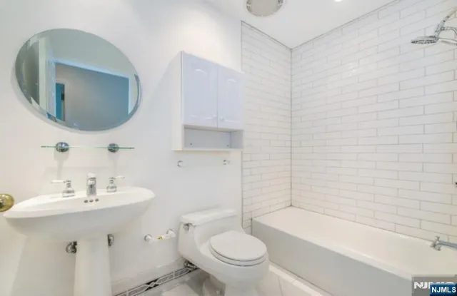 a bathroom with a sink a toilet and bathtub
