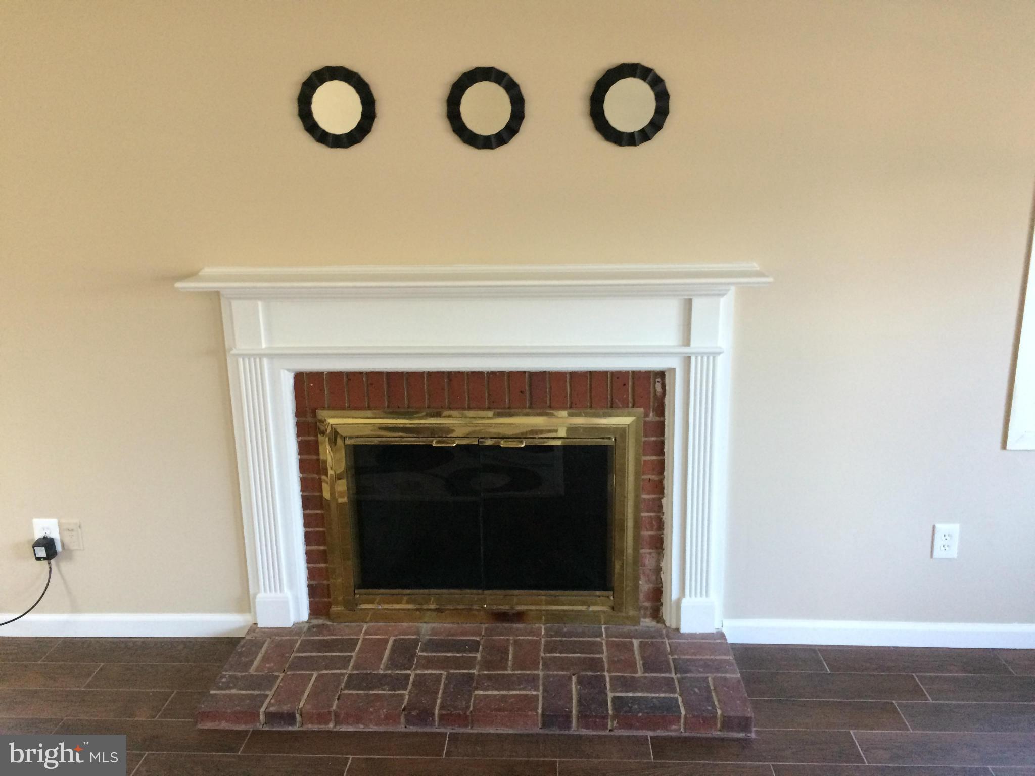 12612 Cedarbrook Lane Laurel, MD 20708 - Photo 12 of 22 a stone fireplace with a clock on it