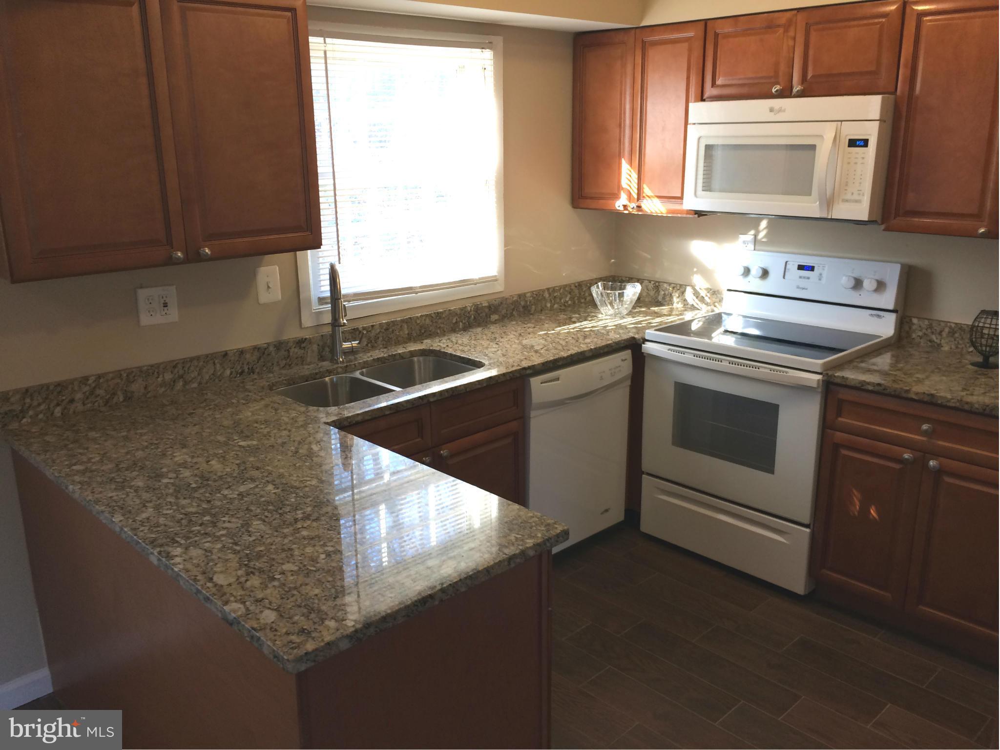 12612 Cedarbrook Lane Laurel, MD 20708 - Photo 18 of 22 a kitchen with stainless steel appliances granite countertop a sink stove and microwave