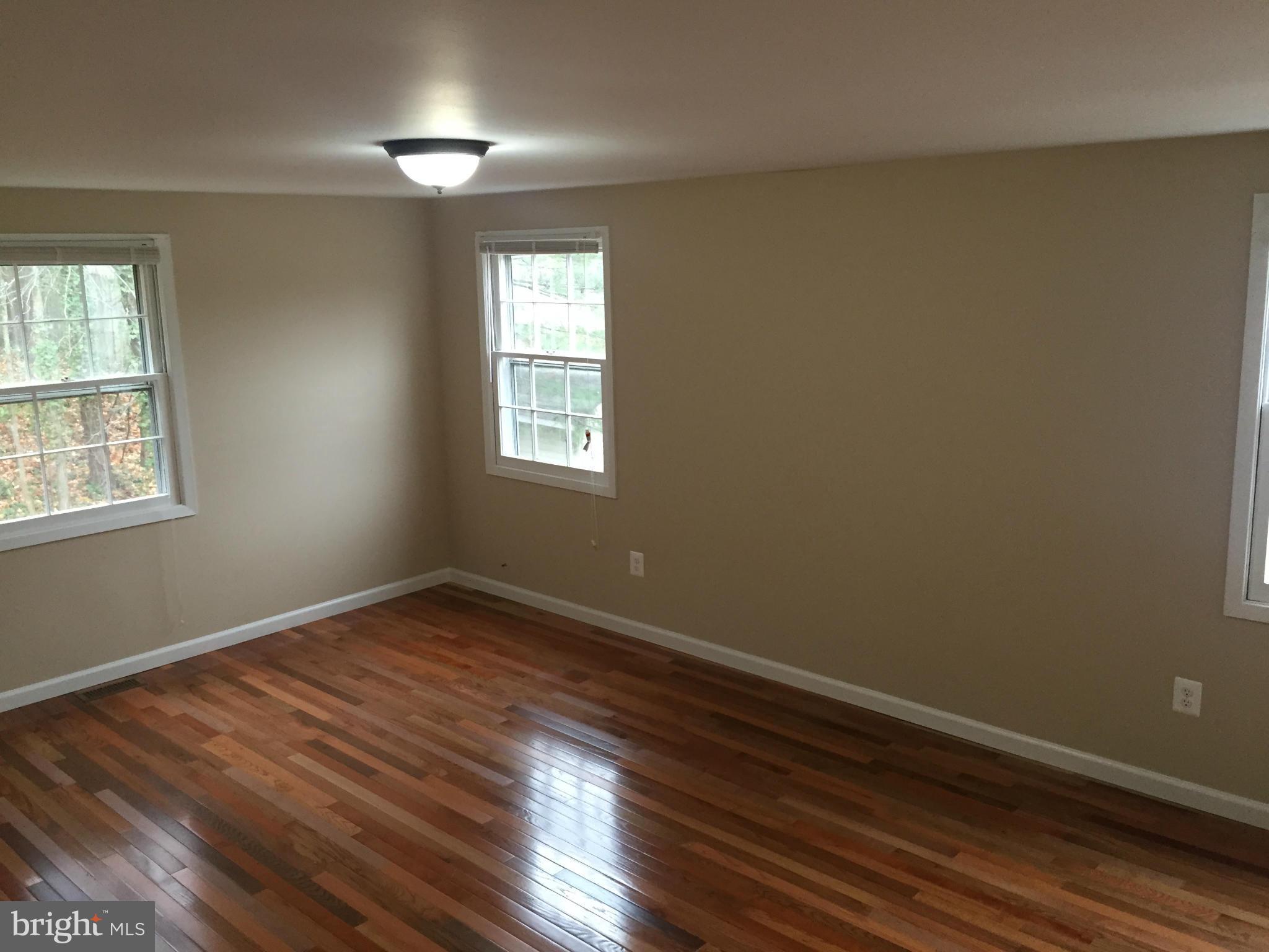 12612 Cedarbrook Lane Laurel, MD 20708 - Photo 4 of 22 a view of an empty room with wooden floor and a window
