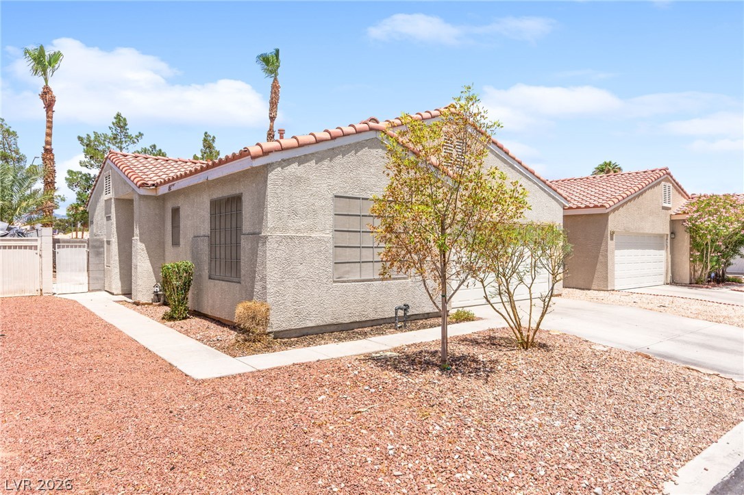 7353 Ridge Star Court Las Vegas, NV 89131 - Photo 6 of 36 A well-maintained stucco home with a traditional tile roof and desert-friendly landscaping.