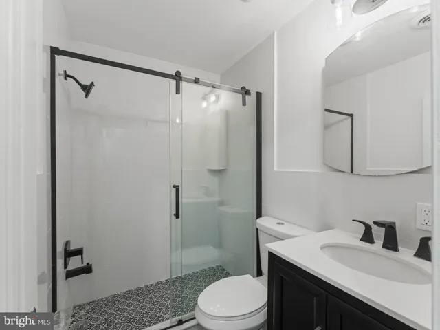 a bathroom with a sink toilet vanity and shower