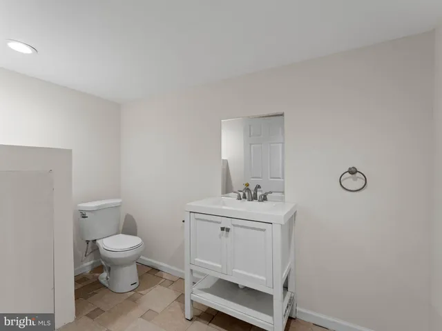 a bathroom with a toilet a sink and mirror