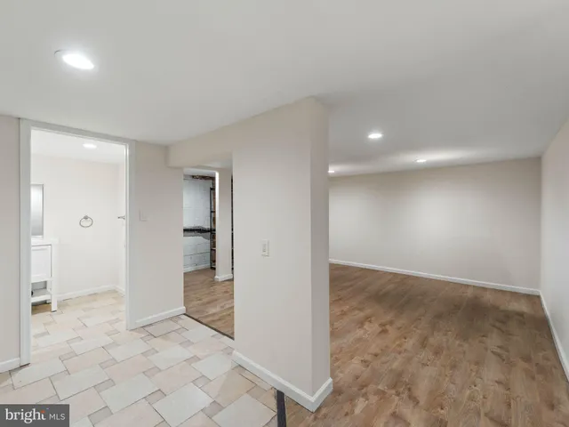 an empty room with kitchen space and windows