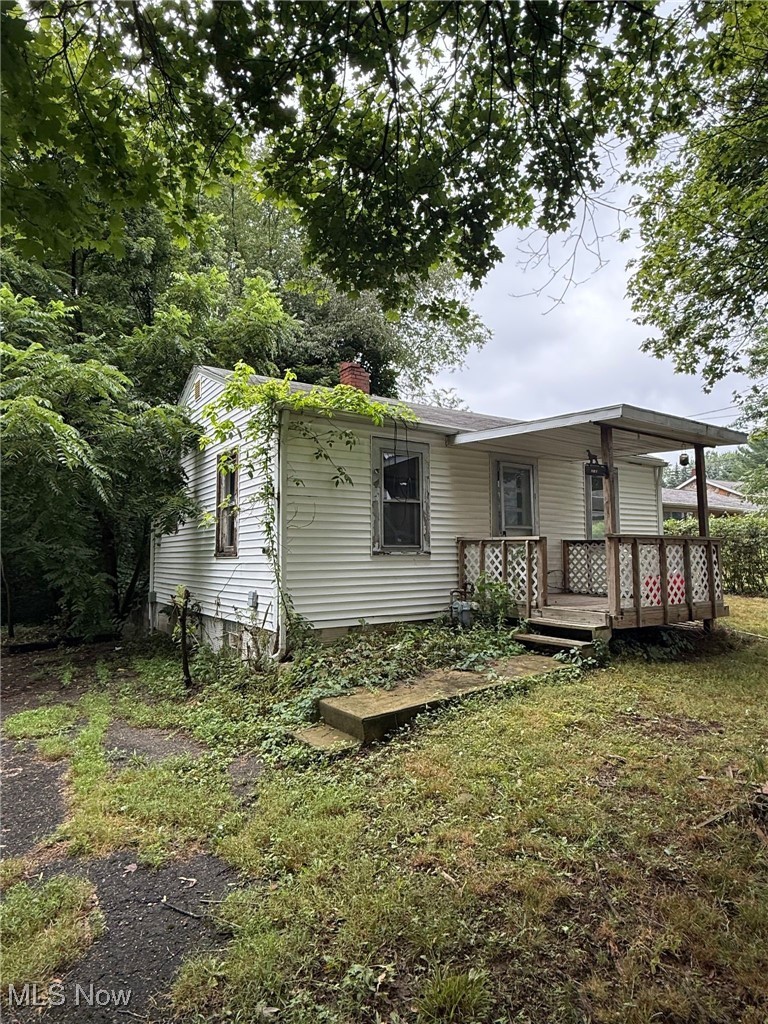 2188 Stahl Road Akron, OH 44319 - Photo 2 of 5 Back of house featuring a chimney, a wooden deck, and a lawn