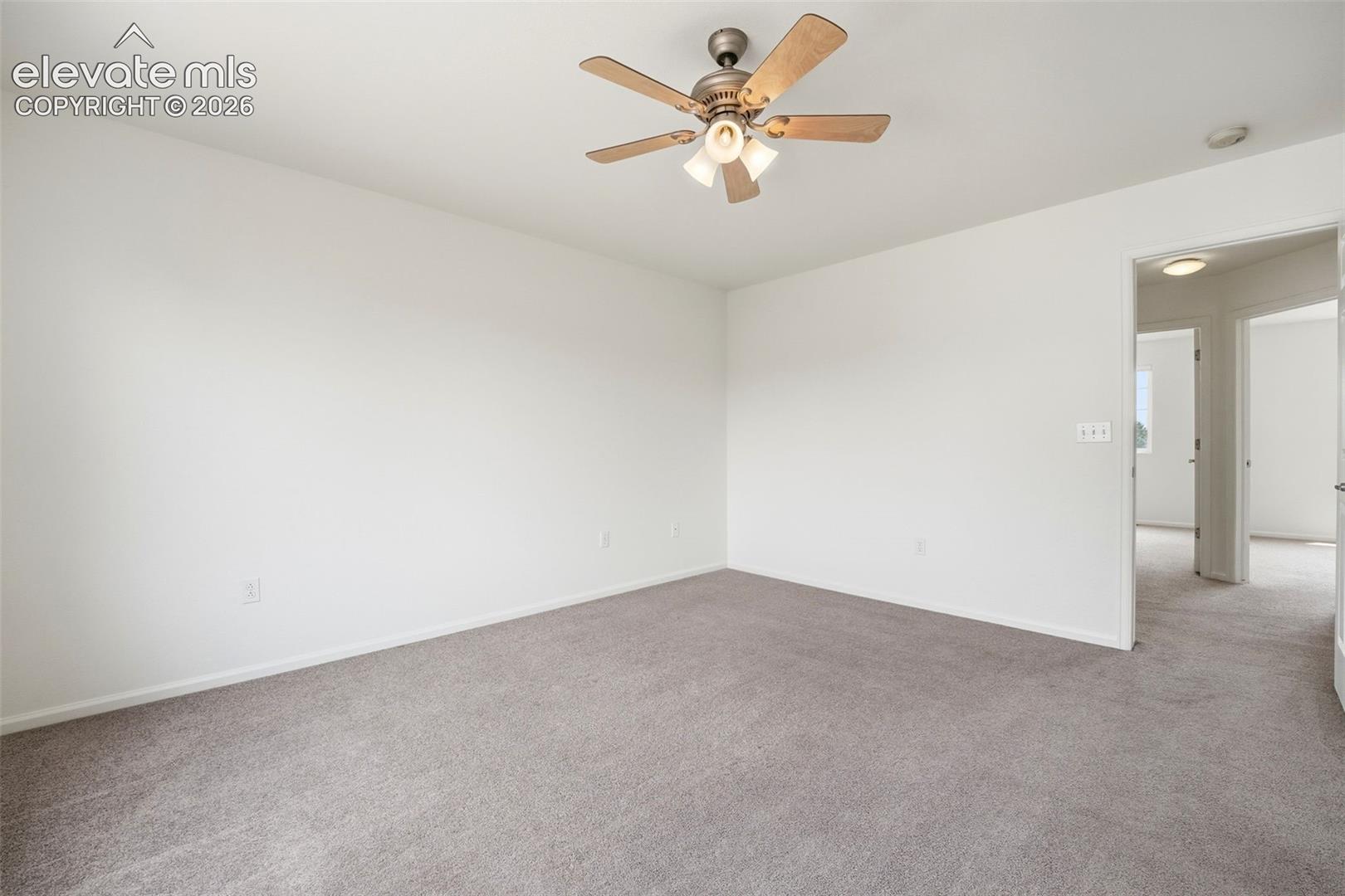 7904 Coffee Road Peyton, CO 80831 - Photo 23 of 48 Spacious room featuring neutral carpeting, white walls, a ceiling fan with light fixture, and white trim