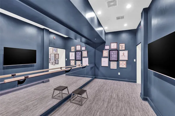 a living room with a flat screen tv on wall and a flat screen tv