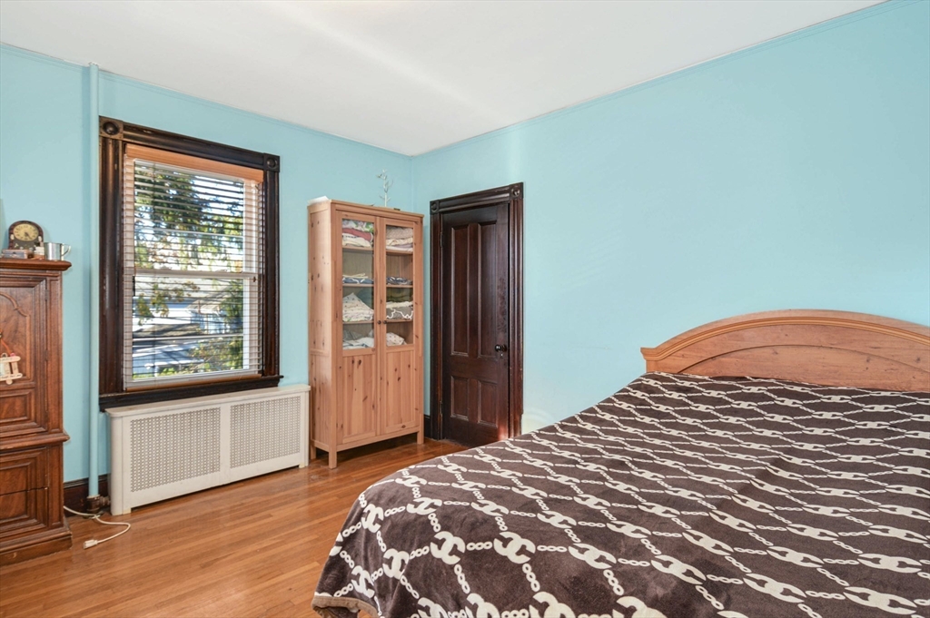 10 Middle Street, Unit 10 Newton, MA 02458 - Photo 13 of 19 a bedroom with a bed and wooden floor