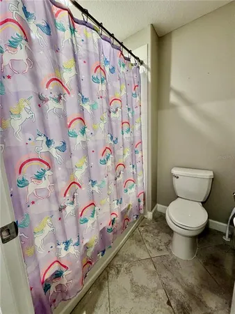 a bathroom with a toilet and shower curtain