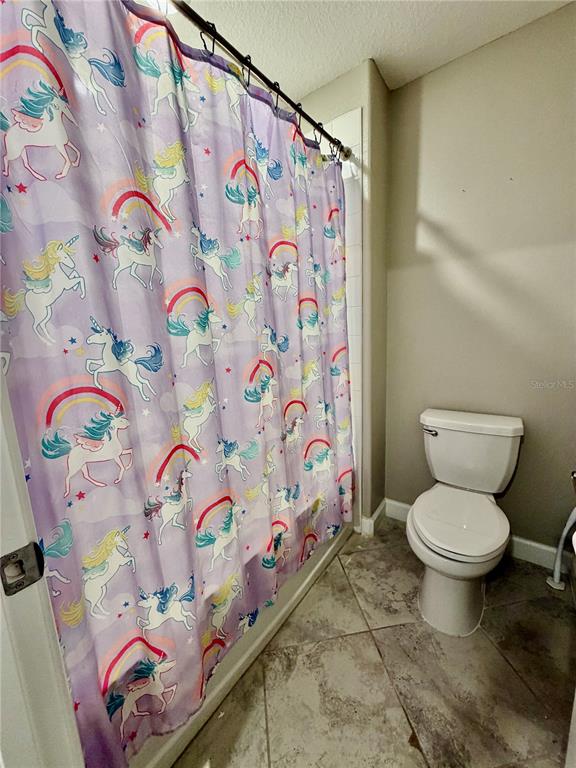 25118 Lambrusco Loop Lutz, FL 33559 - Photo 8 of 26 a bathroom with a toilet and shower curtain