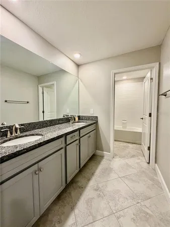 a spacious bathroom with a granite countertop sink a mirror and a