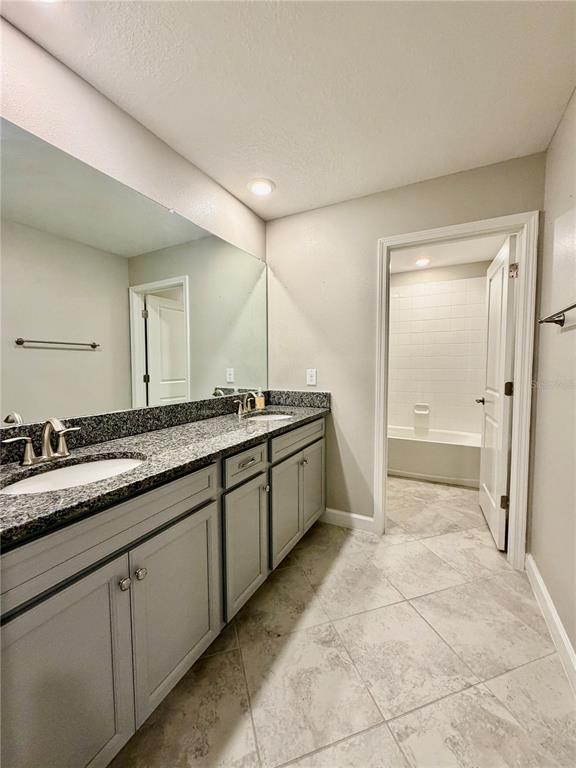 25118 Lambrusco Loop Lutz, FL 33559 - Photo 10 of 26 a spacious bathroom with a granite countertop sink a mirror and a