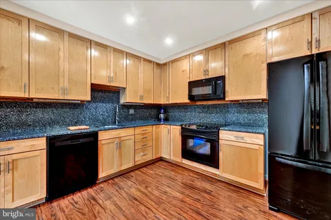 a kitchen with stainless steel appliances granite countertop wooden cabinets a stove top oven a sink and dishwasher