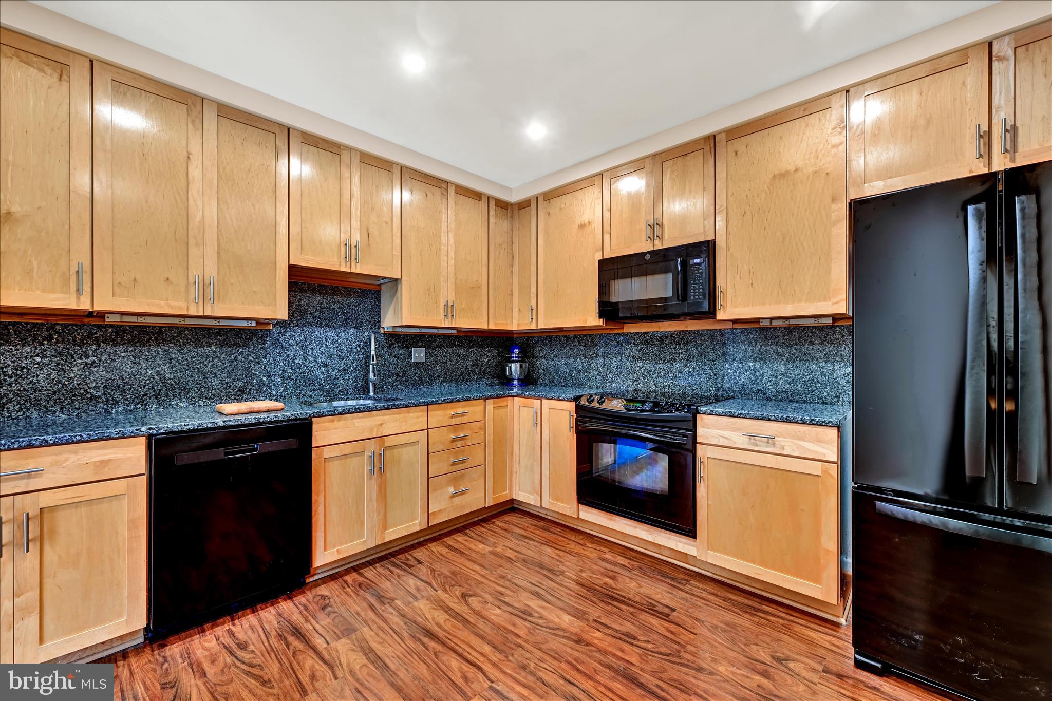 2317 Wonderview Road Lutherville-Timonium, MD 21093 - Photo 7 of 27 a kitchen with stainless steel appliances granite countertop wooden cabinets a stove top oven a sink and dishwasher