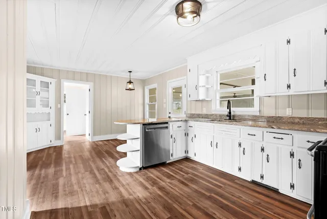 a kitchen with granite countertop a sink cabinets stainless steel appliances and a counter space