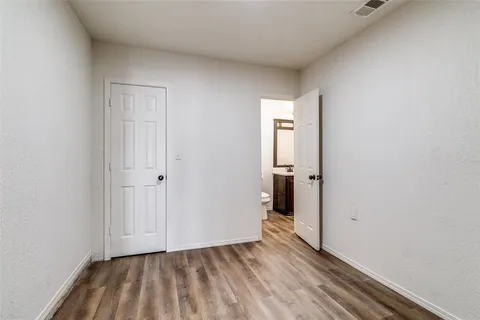 a view of hallway with closet and wooden floor