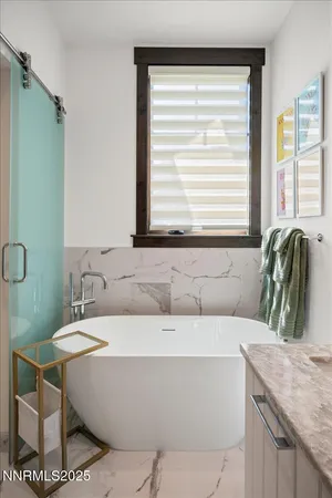 a bathroom with a granite countertop sink and a bathtub