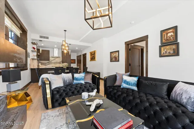 a living room with furniture a rug and kitchen view
