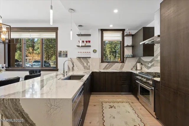 a kitchen with granite countertop a stove a sink and a refrigerator