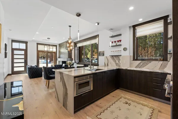 a kitchen with stainless steel appliances granite countertop a stove a sink and a microwave