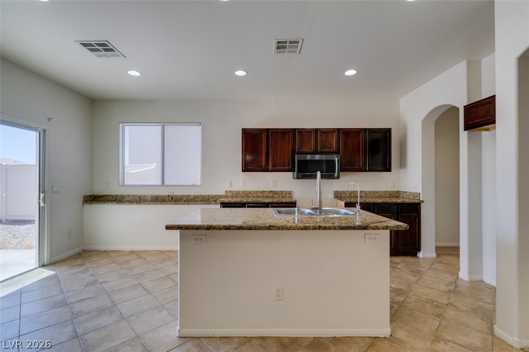 5150 Riverside Run Court North Las Vegas, NV 89081 - Photo 31 of 50 A well-appointed kitchen features rich cabinetry, granite countertops, a central island, and direct outdoor access.