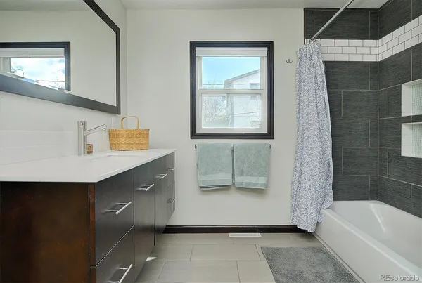 a bathroom with a tub sink and mirror
