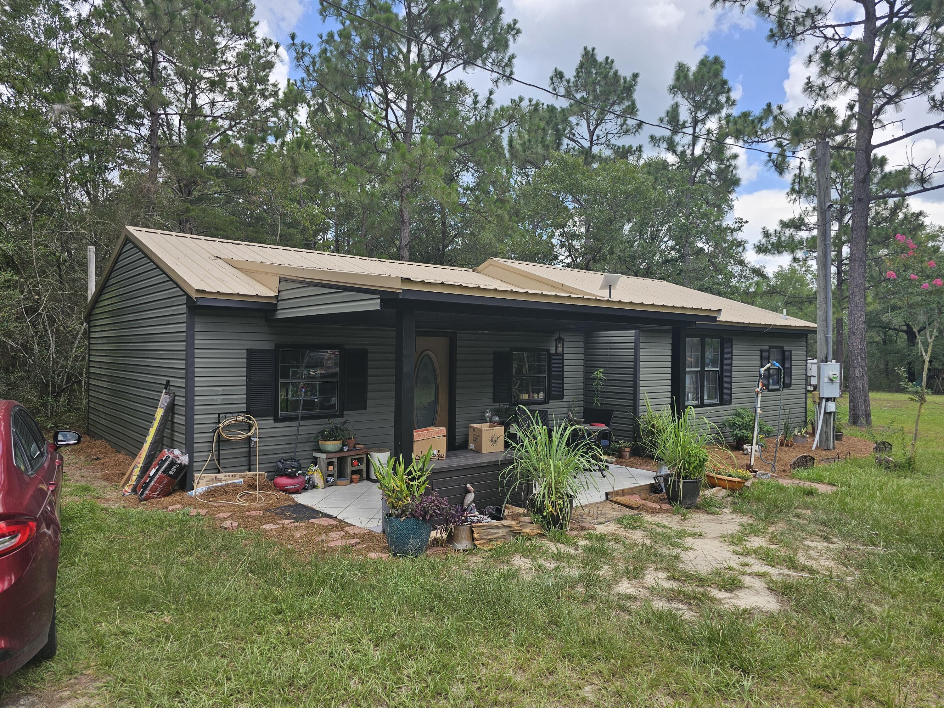 a view of a house with backyard sitting area and garden