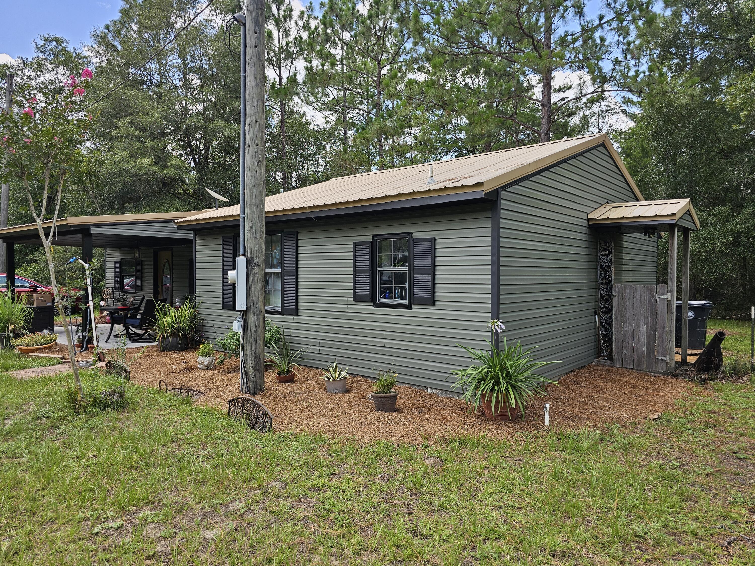 400 7 Oaks Road DeFuniak Springs, FL 32433 - Photo 2 of 17 a view of a chair and table in backyard of the house