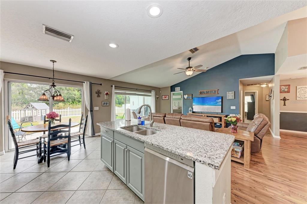 4608 Oliver Manor Drive Parrish, FL 34219 - Photo 11 of 45 a kitchen with stainless steel appliances granite countertop sink stove top oven and cabinets