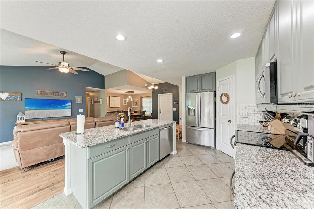 4608 Oliver Manor Drive Parrish, FL 34219 - Photo 10 of 45 a kitchen with stainless steel appliances kitchen island granite countertop a sink and cabinets