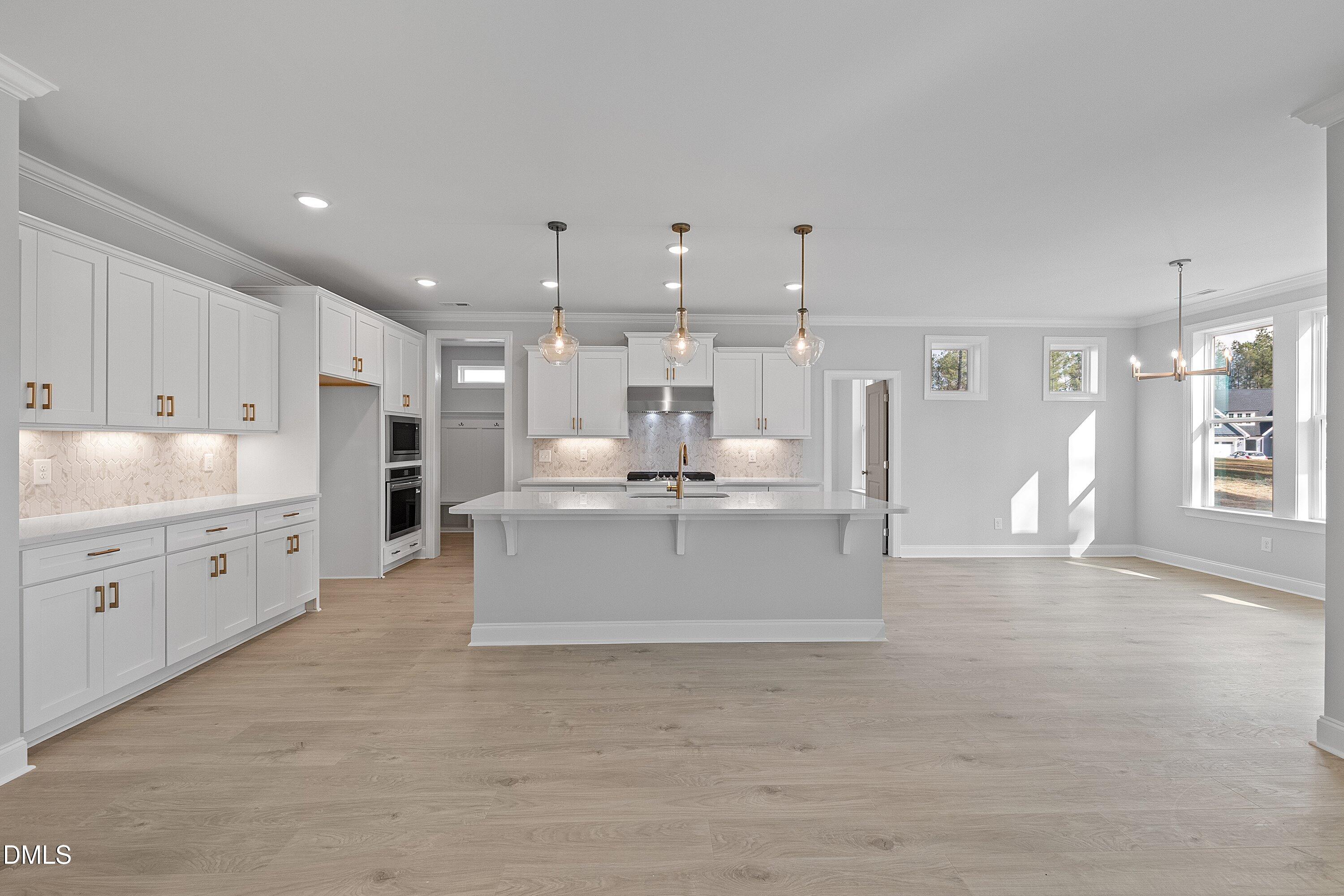 45 West Victoria Ridge Drive, Unit 32 Selma, NC 27576 - Photo 11 of 29 a large white kitchen with kitchen island a sink a stove and a refrigerator