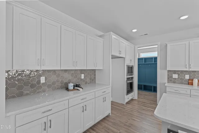 a kitchen with stainless steel appliances granite countertop a refrigerator sink and white cabinets
