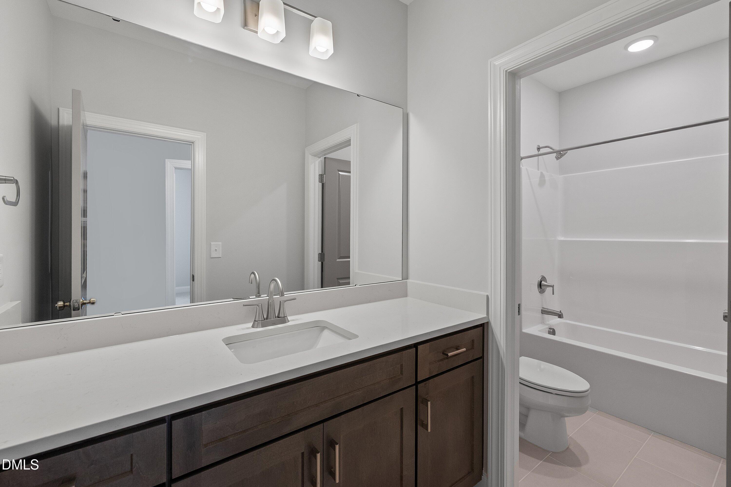 45 West Victoria Ridge Drive, Unit 32 Selma, NC 27576 - Photo 25 of 29 a bathroom with a granite countertop sink toilet a large mirror and shower