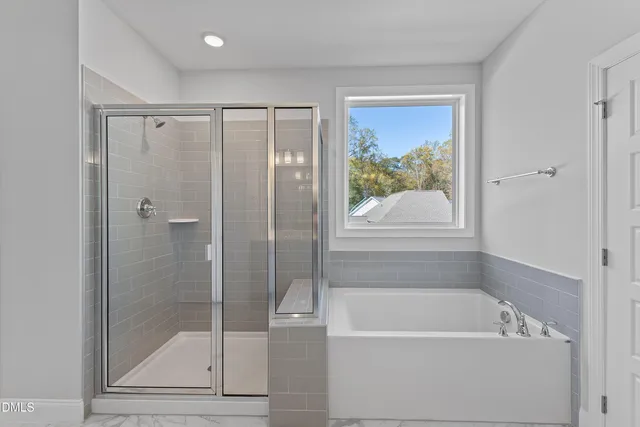 a bathroom with a large tub a shower and view