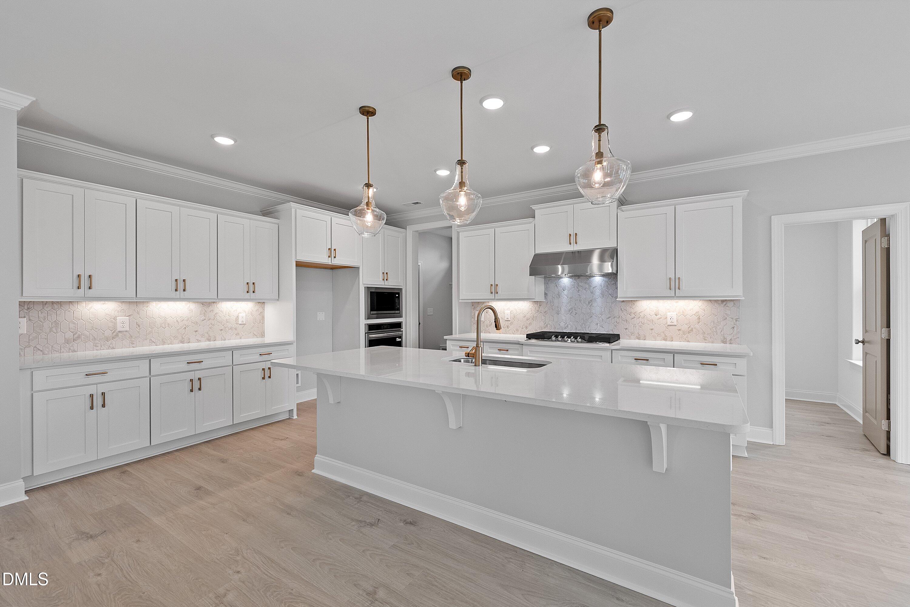 45 West Victoria Ridge Drive, Unit 32 Selma, NC 27576 - Photo 4 of 29 a large kitchen with kitchen island a sink a center island stainless steel appliances and cabinets