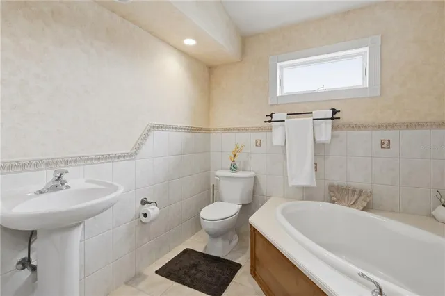 a bathroom with a sink toilet and a mirror