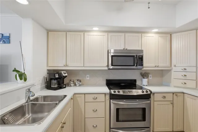 a kitchen with stainless steel appliances granite countertop a sink stove and microwave
