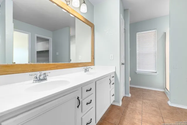 a spacious bathroom with a double vanity sink and mirror