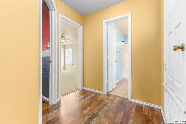 a view of an empty room with wooden floor