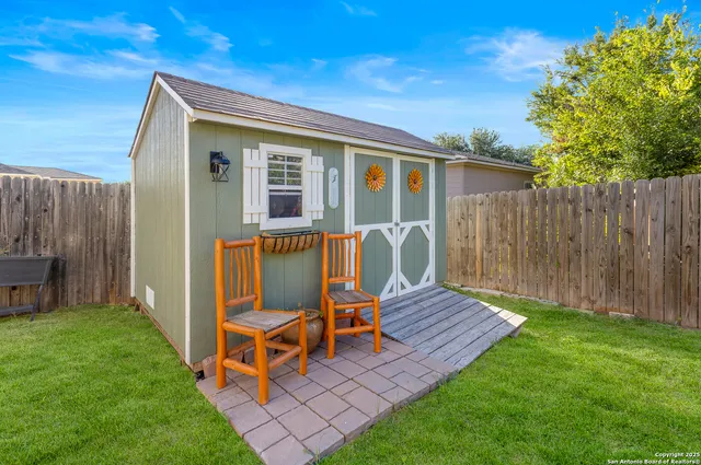 a view of house with backyard and wooden fence