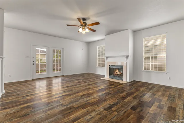 a view of an empty room with window and fire place