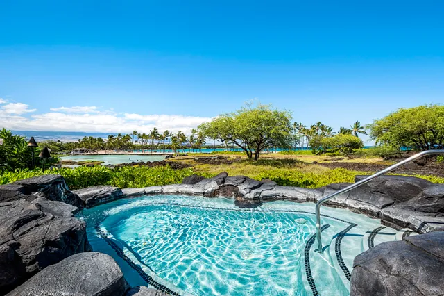 a view of a swimming pool and lounge chairs in back yard of the house