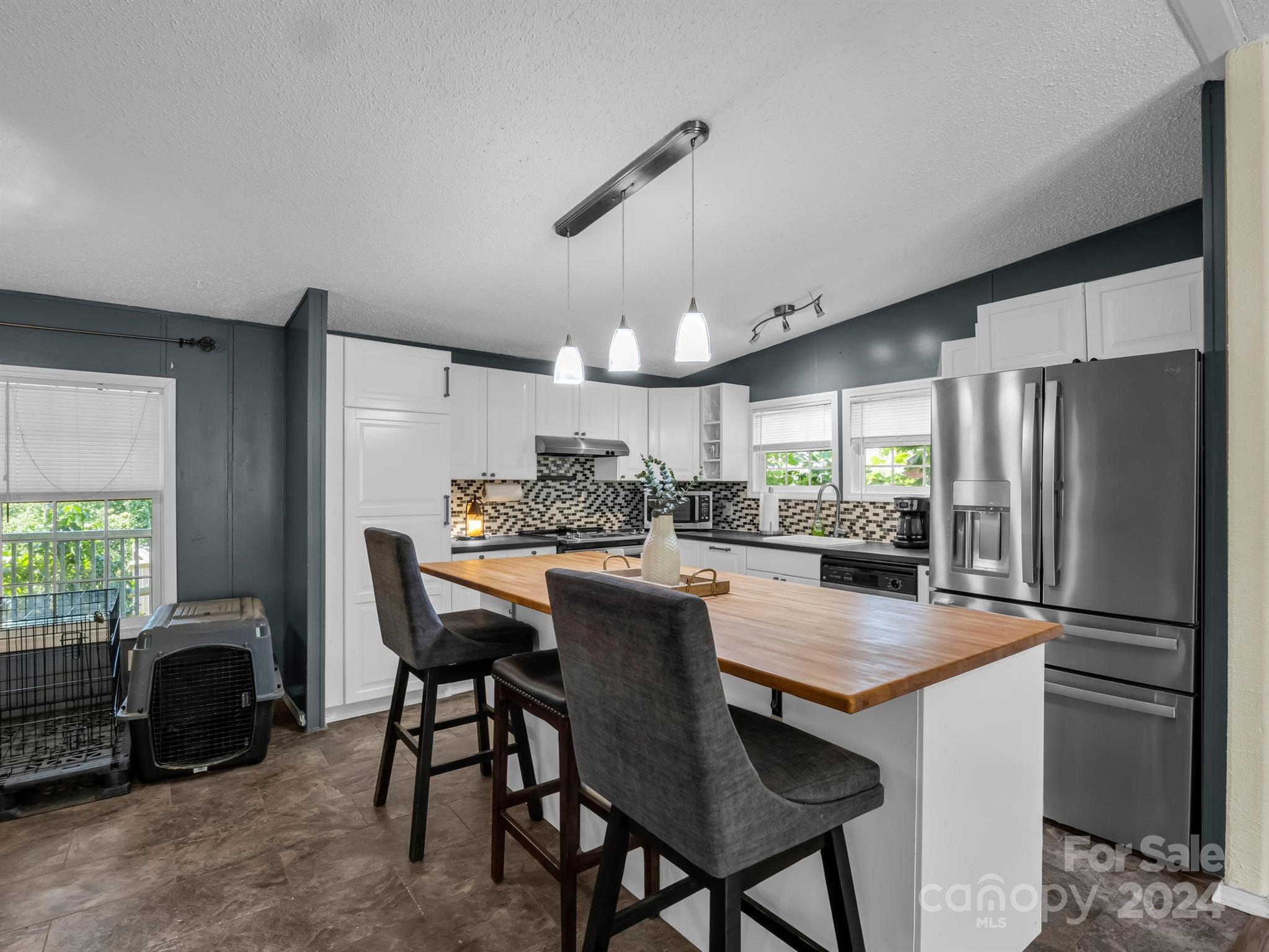293 Bane Road Mills River, NC 28759 - Photo 11 of 48 a kitchen with kitchen island a refrigerator dining table and chairs