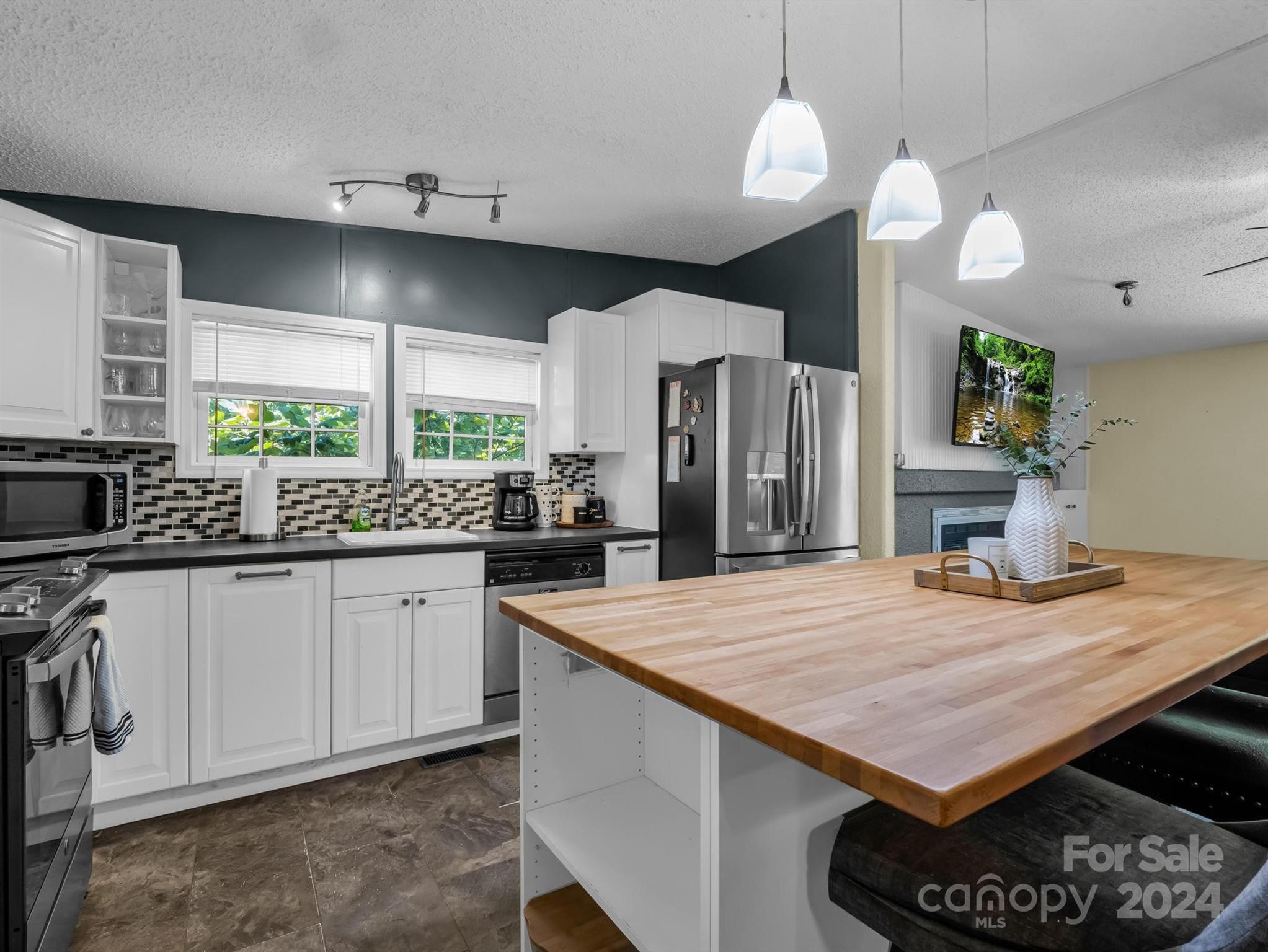 293 Bane Road Mills River, NC 28759 - Photo 13 of 48 a kitchen with stainless steel appliances a table chairs in it and wooden floors