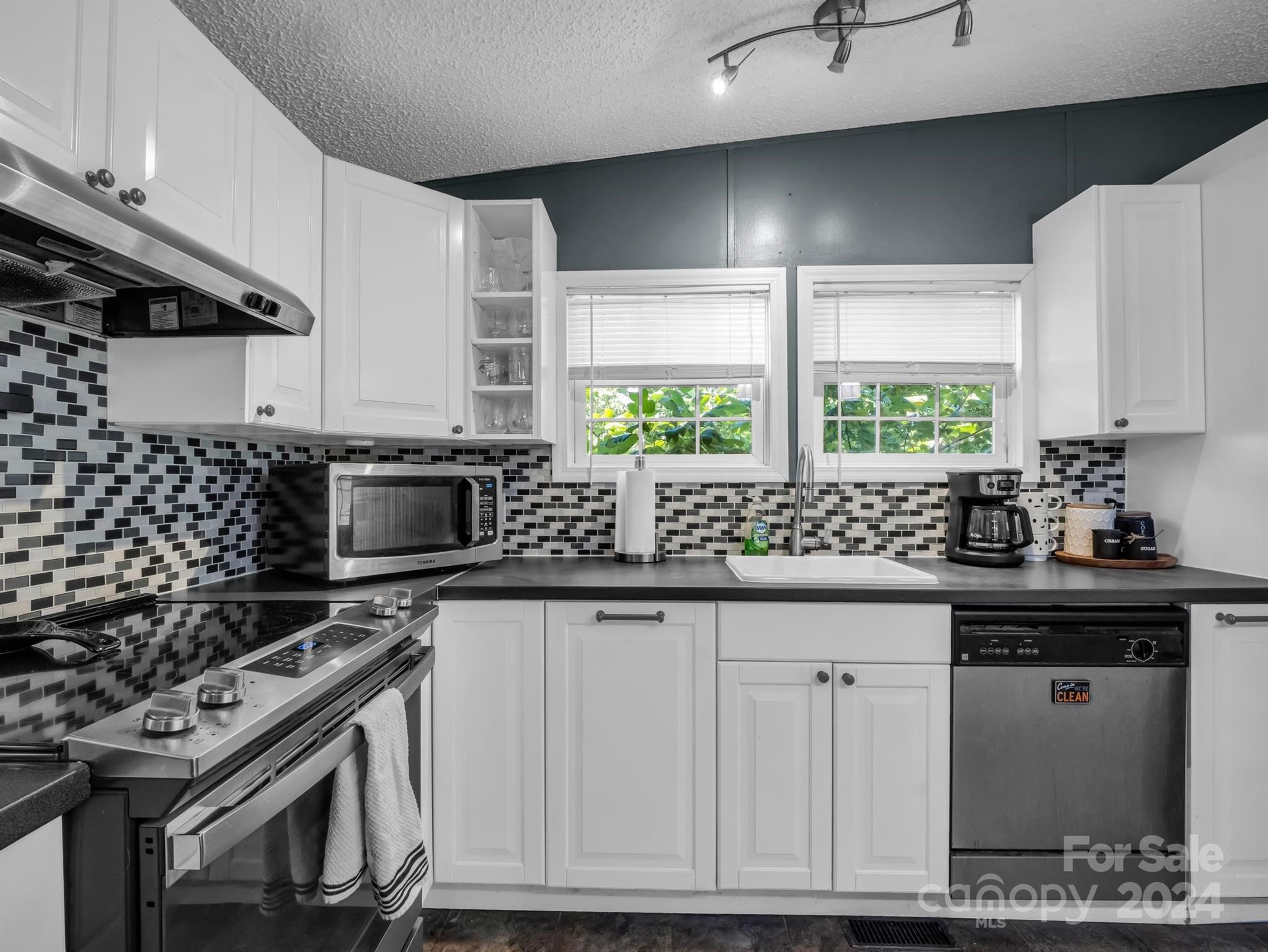 293 Bane Road Mills River, NC 28759 - Photo 14 of 48 a kitchen with granite countertop a sink a window stainless steel appliances and cabinets