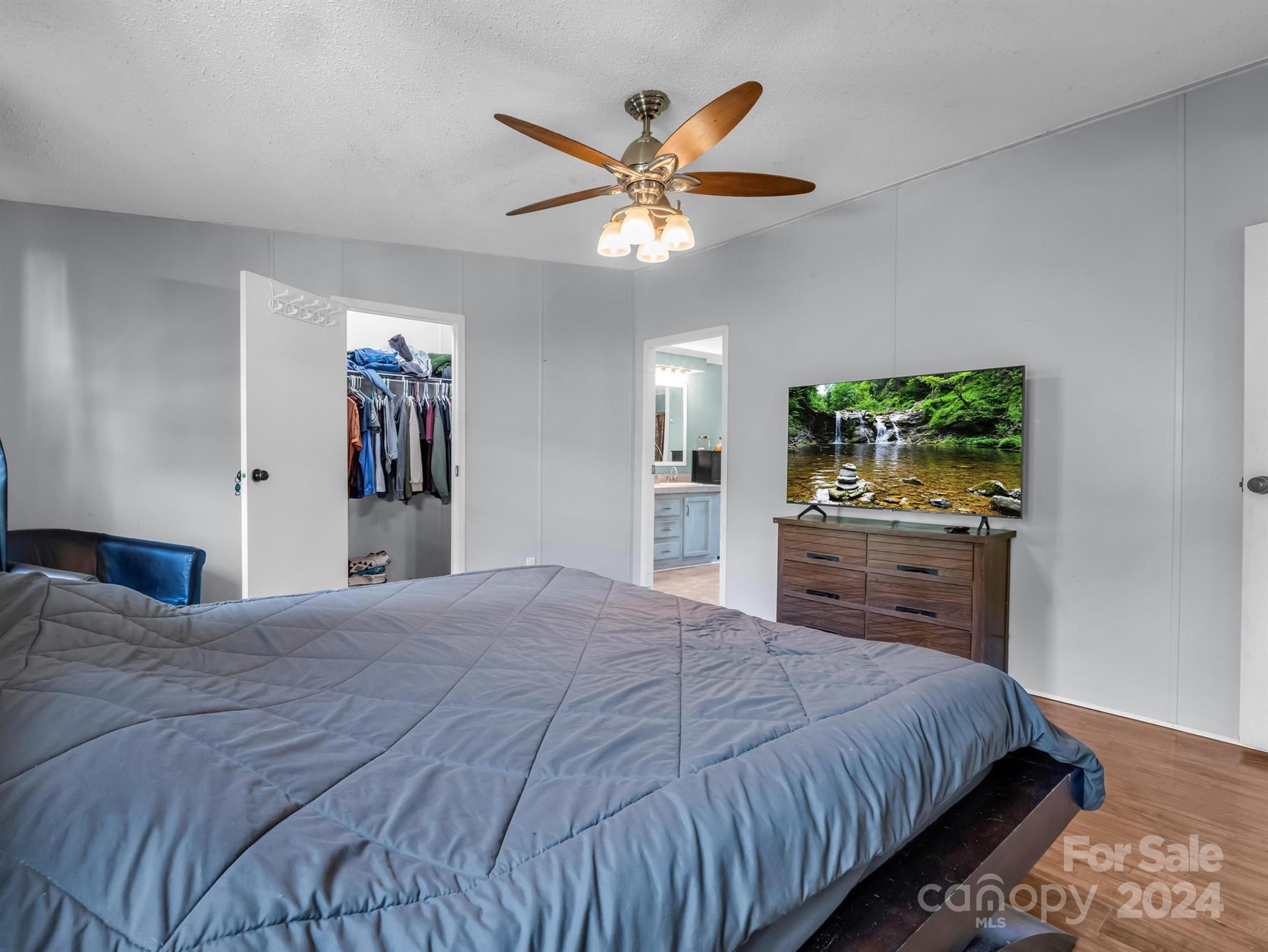 293 Bane Road Mills River, NC 28759 - Photo 19 of 48 a bedroom with a large bed and a chandelier